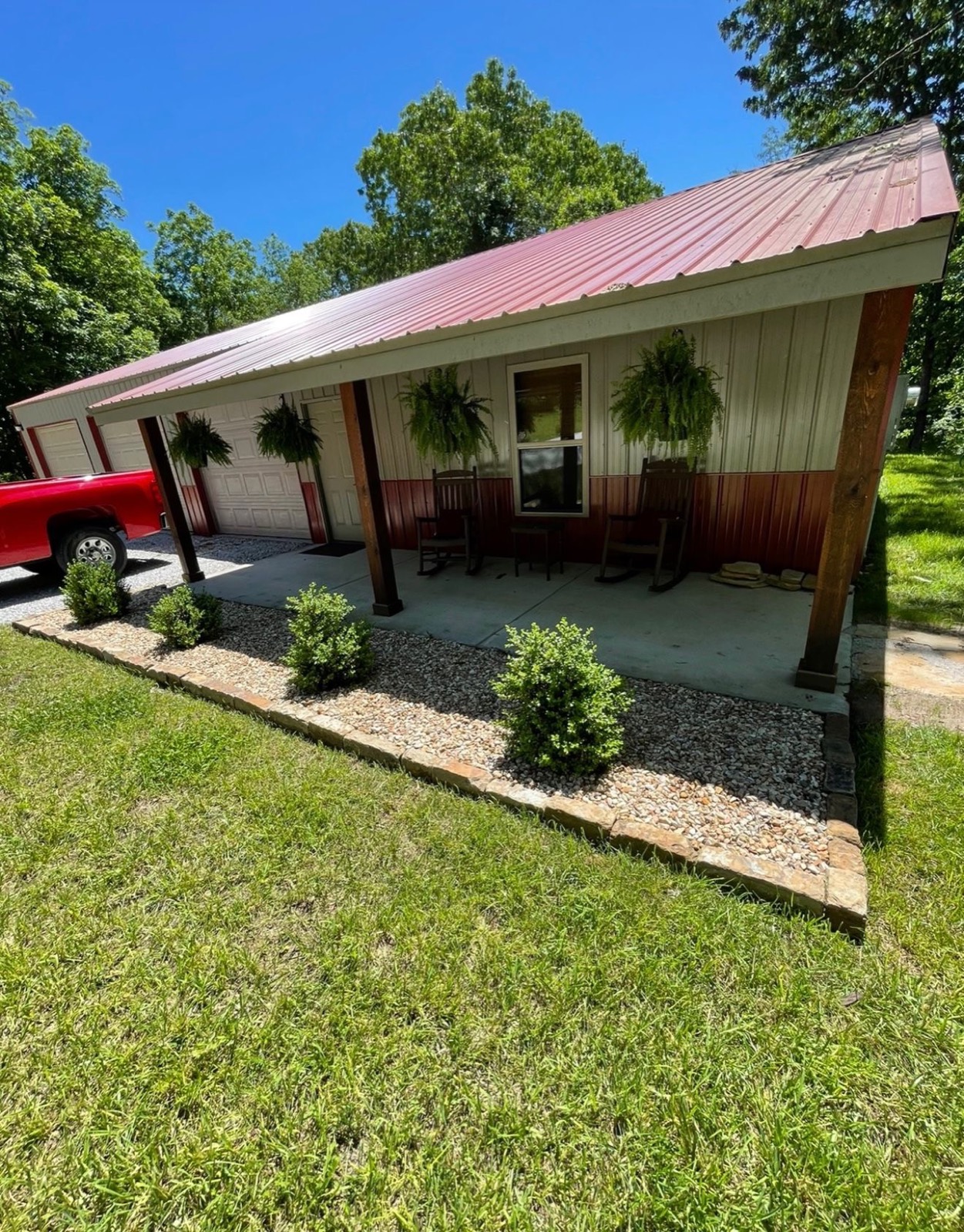Front porch with new shrubs, gravel beds, and hanging baskets