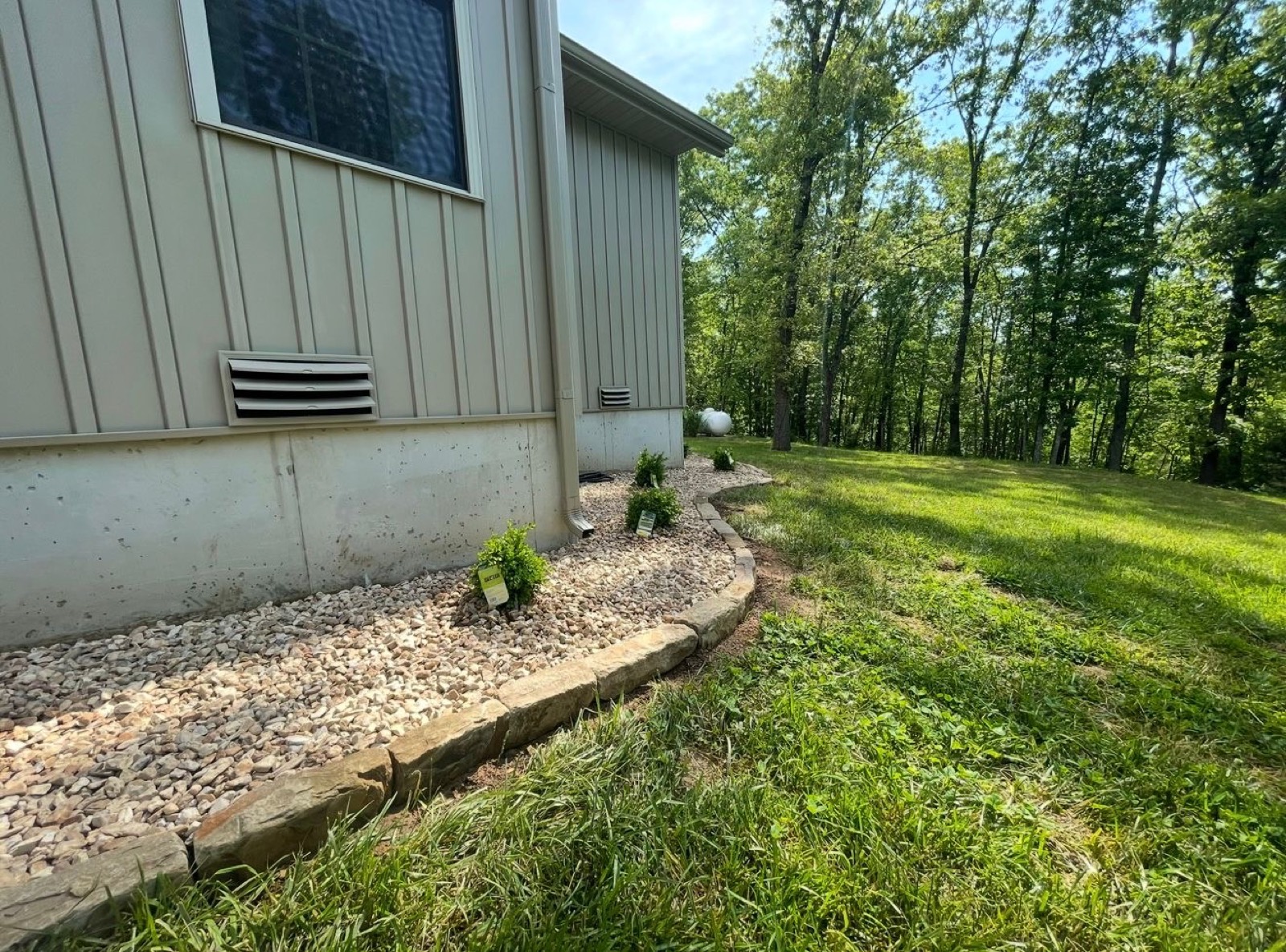 Rock drainage bed running along a house foundation